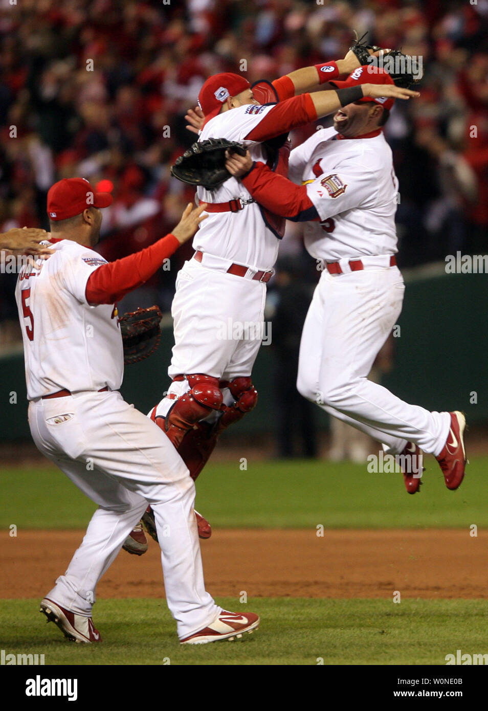 St. Louis Cardinals catcher Yadier Molina (C) jumps into the arms of  teammate Jim Edmonds while Albert Pujols (L) runs along side, as the St.  Louis Cardinals celebrate their World Series victory