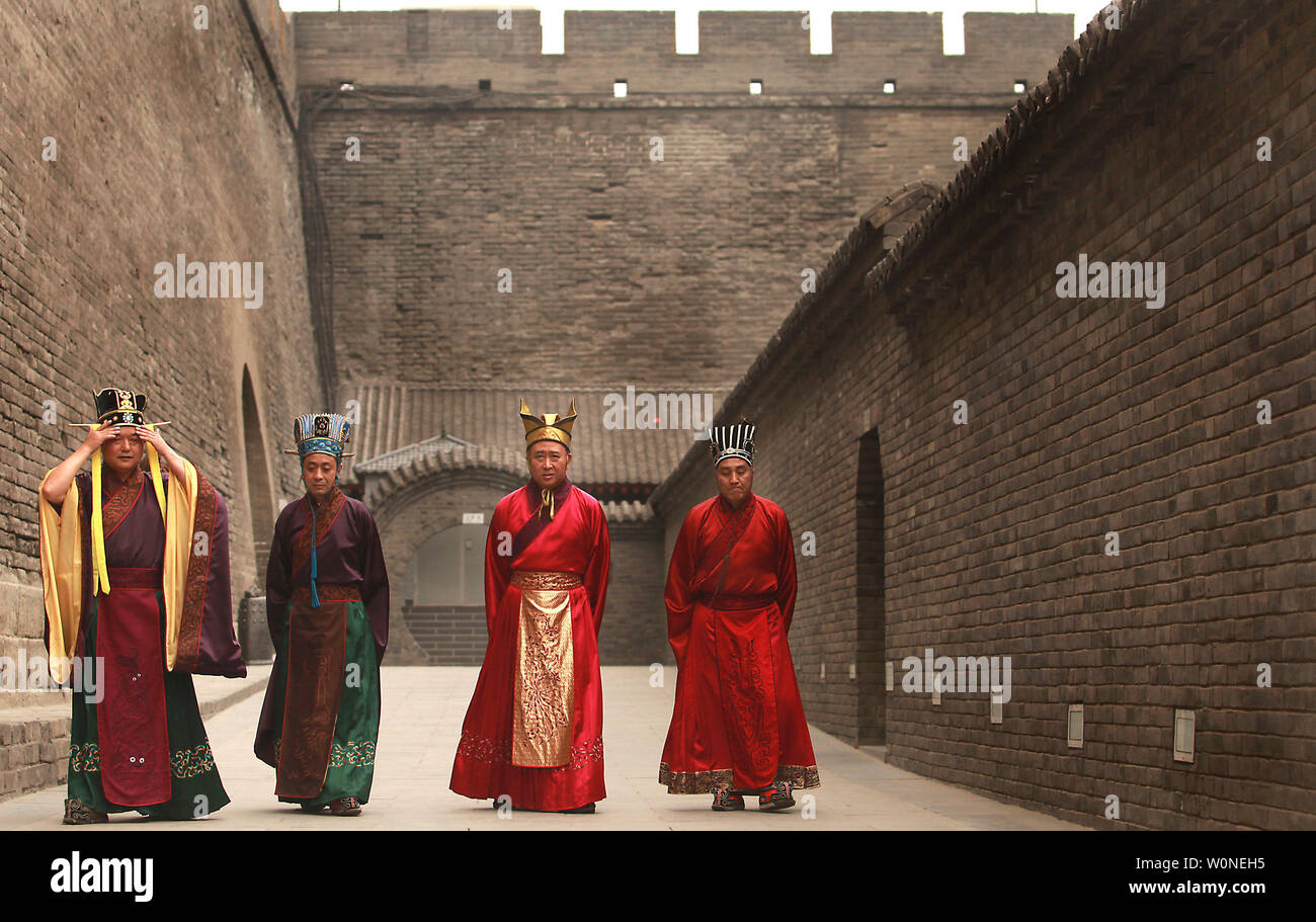 Chinese actors dressed in Tang Dynasty imperial garb walks to an outdoor stage inside the ancient Chinese walled city Xi'an, one of the oldest cities in China and the capital of Shaanxi Province on June 26, 2012.  Xi'an is one of the Four Great Ancient Capitals of China, having maintained the position under several of the most important Chinese dynasties. It is the most complete walled city that has survived in China.    UPI/Stephen Shaver Stock Photo