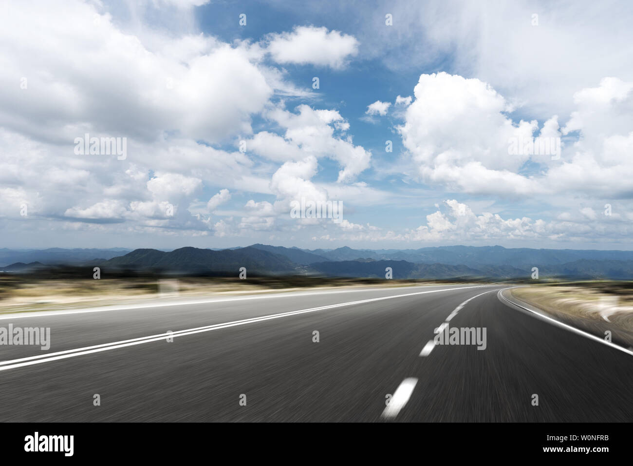 empty asphalt road with green hill in cloud sky Stock Photo - Alamy