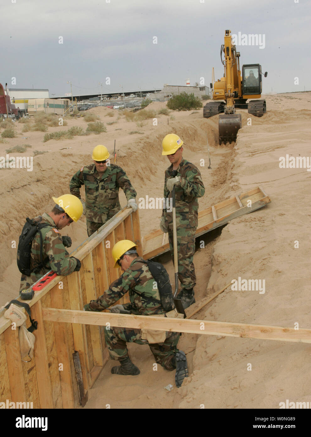 Utah National Guard members Thomas Carter of Roosevelt, Utah; Joshua Richards of Layton, Utah; Brad Young of Toowillow, Utah; and Staff Sgt John Bylsma of Pleasant Grove, Utah install concrete forms to support the fence at the Arizona border with Mexico in San Luis, Arizona June 6, 2006.   More than 50 National Guardsmen from Utah became the first unit to get to work under President George W. Bush's crackdown on illegal immigration.   (UPI Photo/Will Powers) Stock Photo