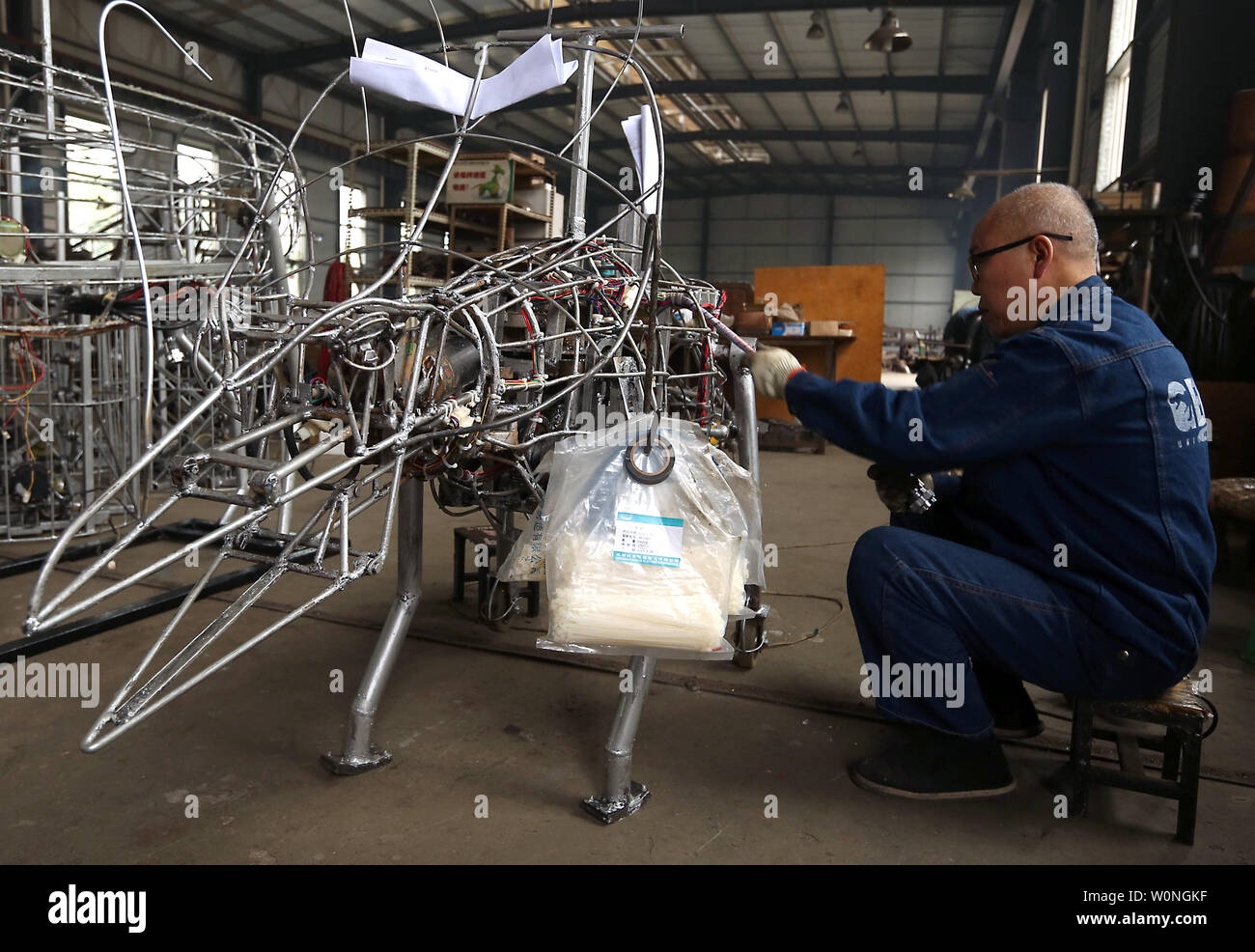 A Chinese technician works on the alloy exoskeleton of a robotic dinosaur at the Gengulongteng Science and Technology Company's production plant in Zigong, Sichuan Province, China on November 18, 2017.  Gengu, the area's leading producer of robotic dinosaurs, as well as over 30 other Chinese companies in Zigong, produce about 90 percent of the simulation dinosaurs exported around the world.    Photo by Stephen Shaver/UPI Stock Photo