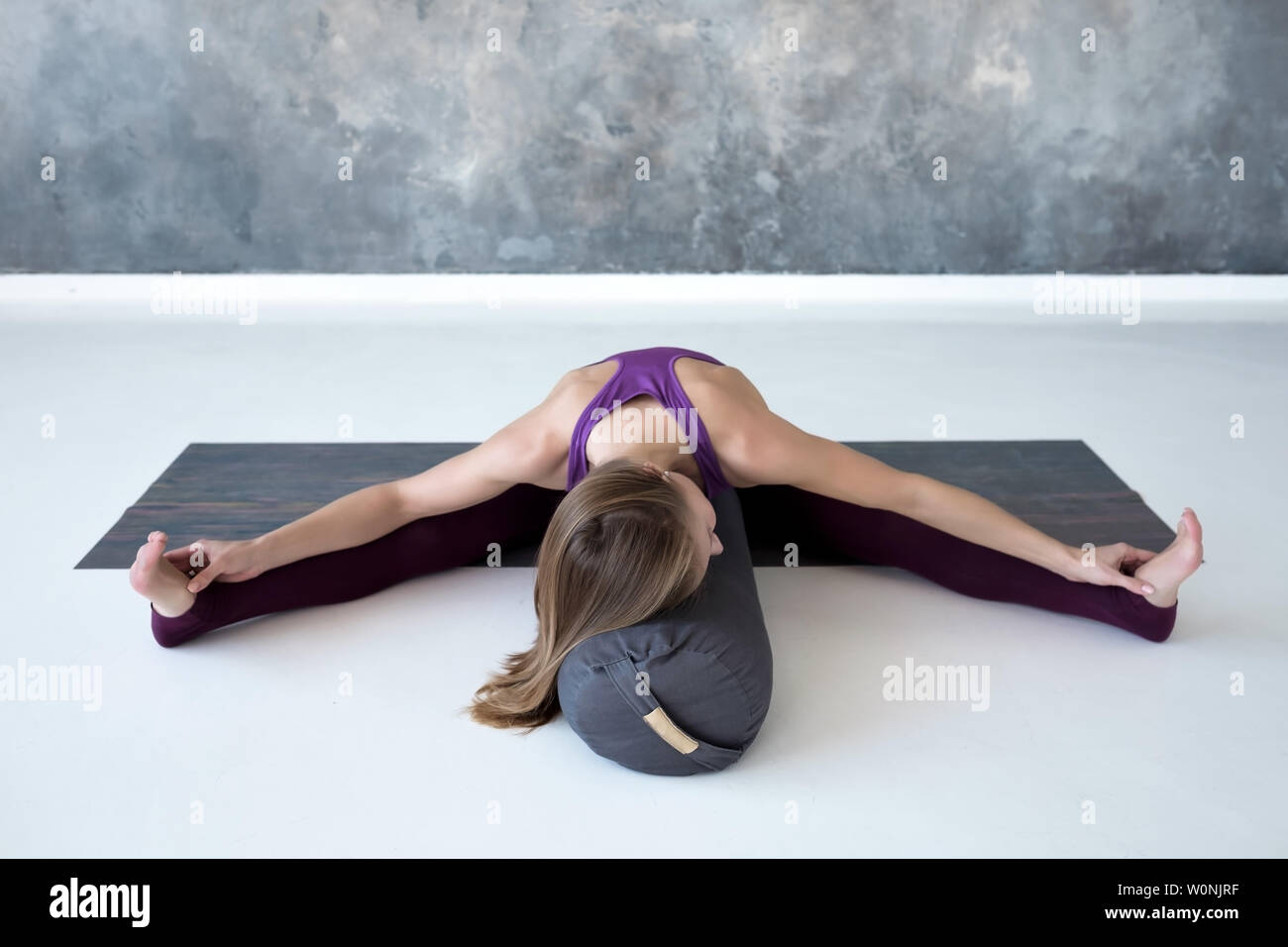 Caucasian woman doing youga splits upavistha konasana on fitness mat Stock Photo