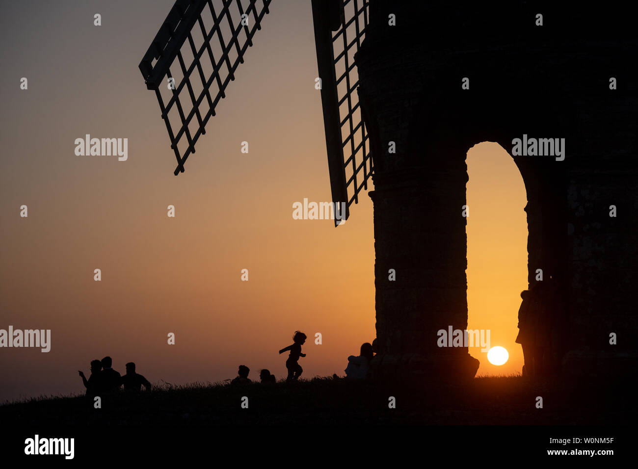 The sun sets by Chesterton Windmill in Warwickshire. The UK is enjoying a warmer spell of weather whilst temperature records are broken across many parts of Europe. Stock Photo