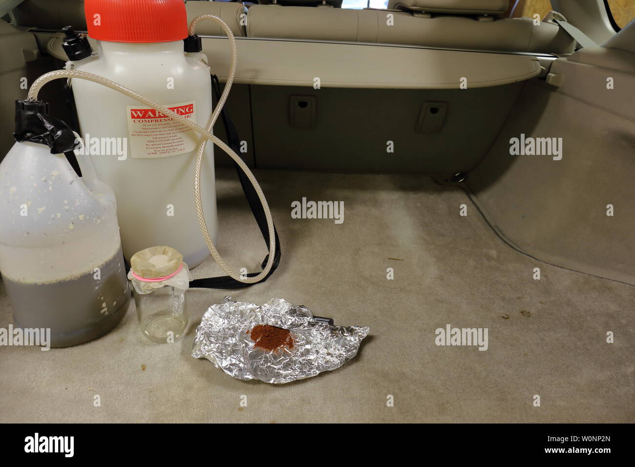 Supplies and chemicals used to manufacture methamphetamine in the back of a vehicle Stock Photo