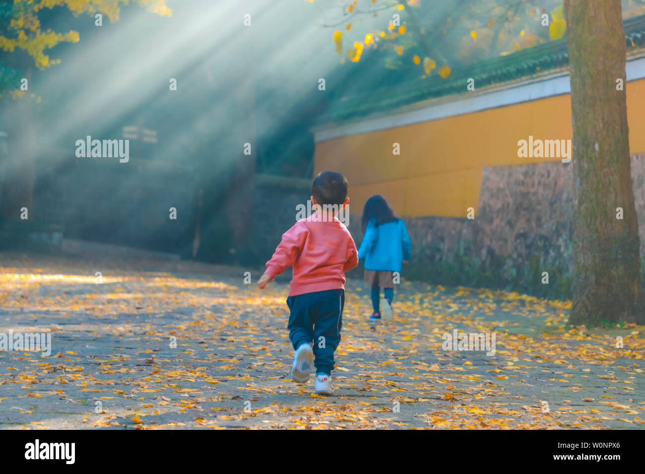 In the Tian Tong Temple in autumn, two naive and lovely children are  running towards a beam of morning light Stock Photo - Alamy