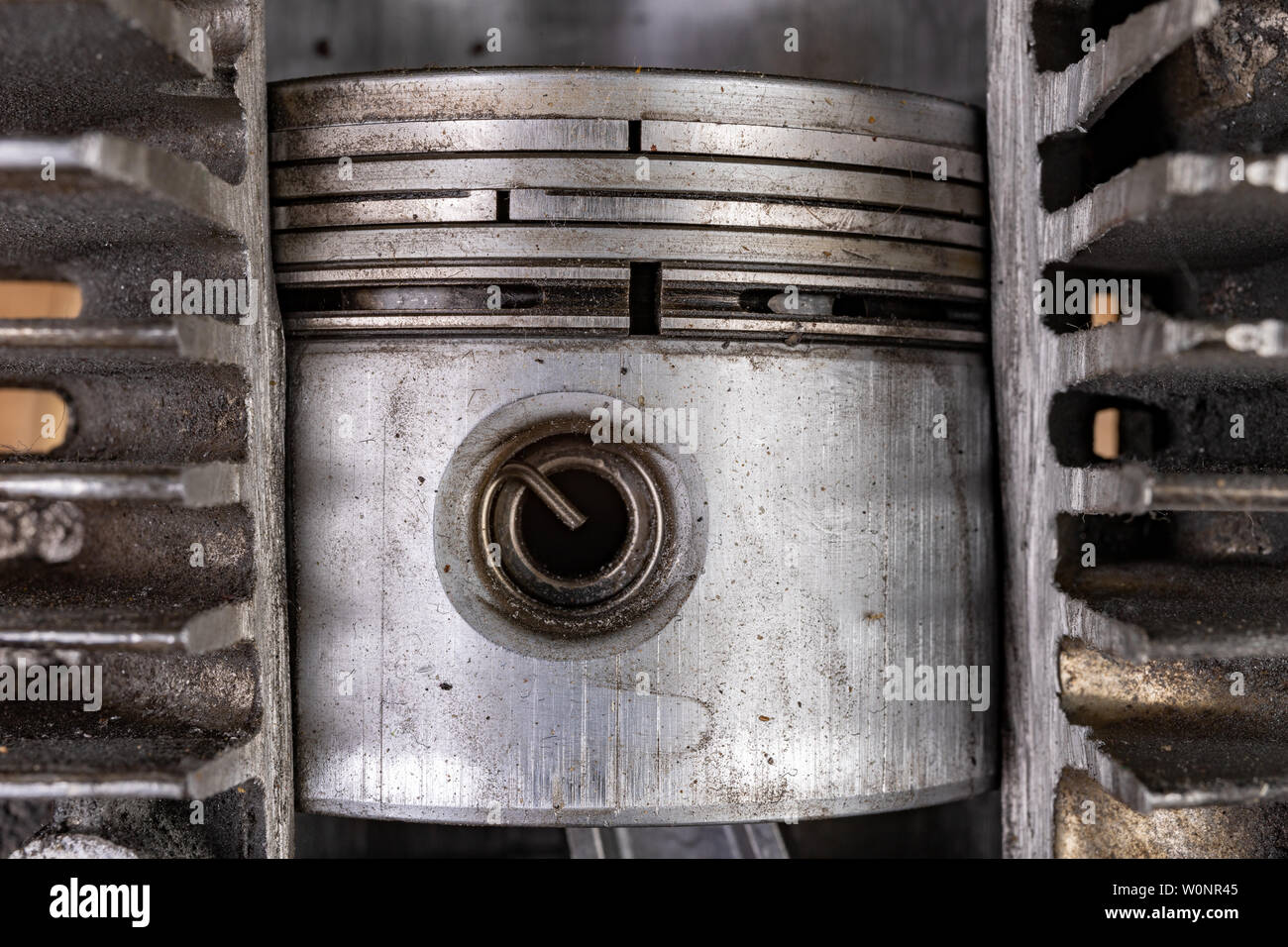 Piston of an internal combustion engine in a cut aluminum cylinder. Internal view of the internal combustion engine. Dark background. Stock Photo