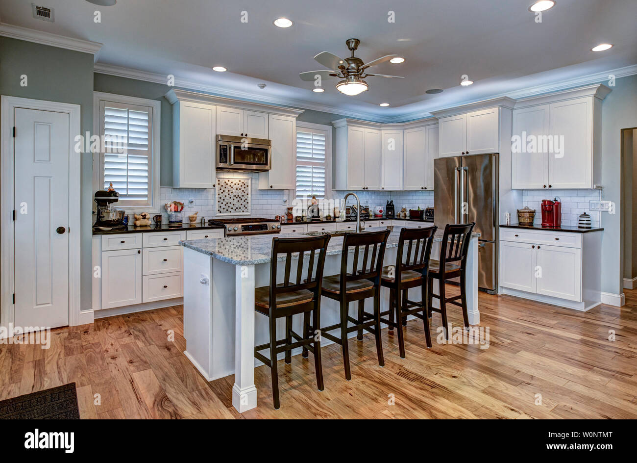 Expensive kitchen with white and hardwood flooring and granite