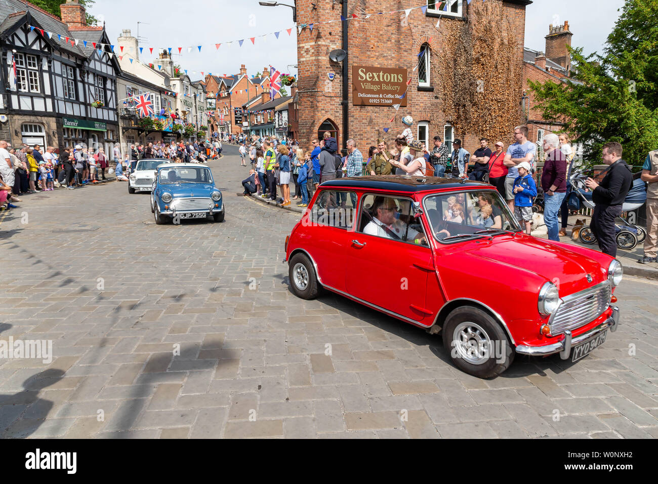 Red, white and blue mini cars similar to The Italian Job parade through