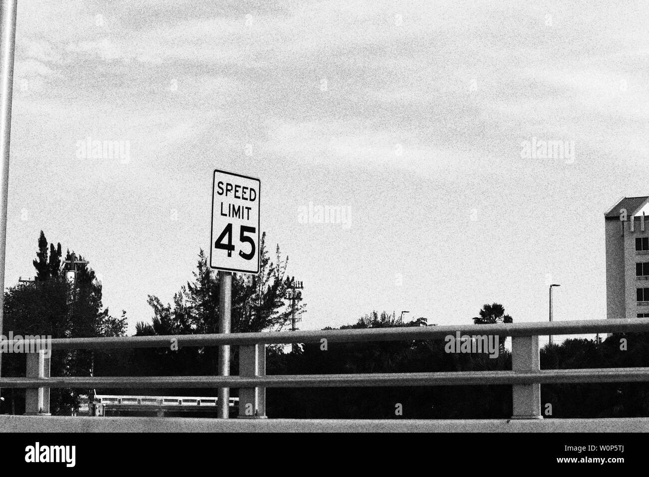 Black and white photograph of speed limit sign on bridge Stock Photo