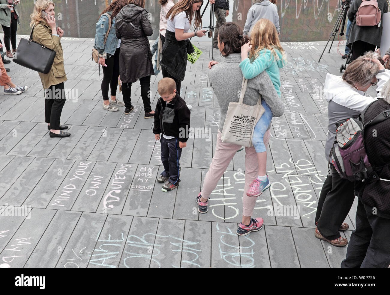A child reads the chalk message 'My Body My Choice' while surrounded by pro-choice rally goers on May 21, 2019 during the Women's Rights Rally. Stock Photo