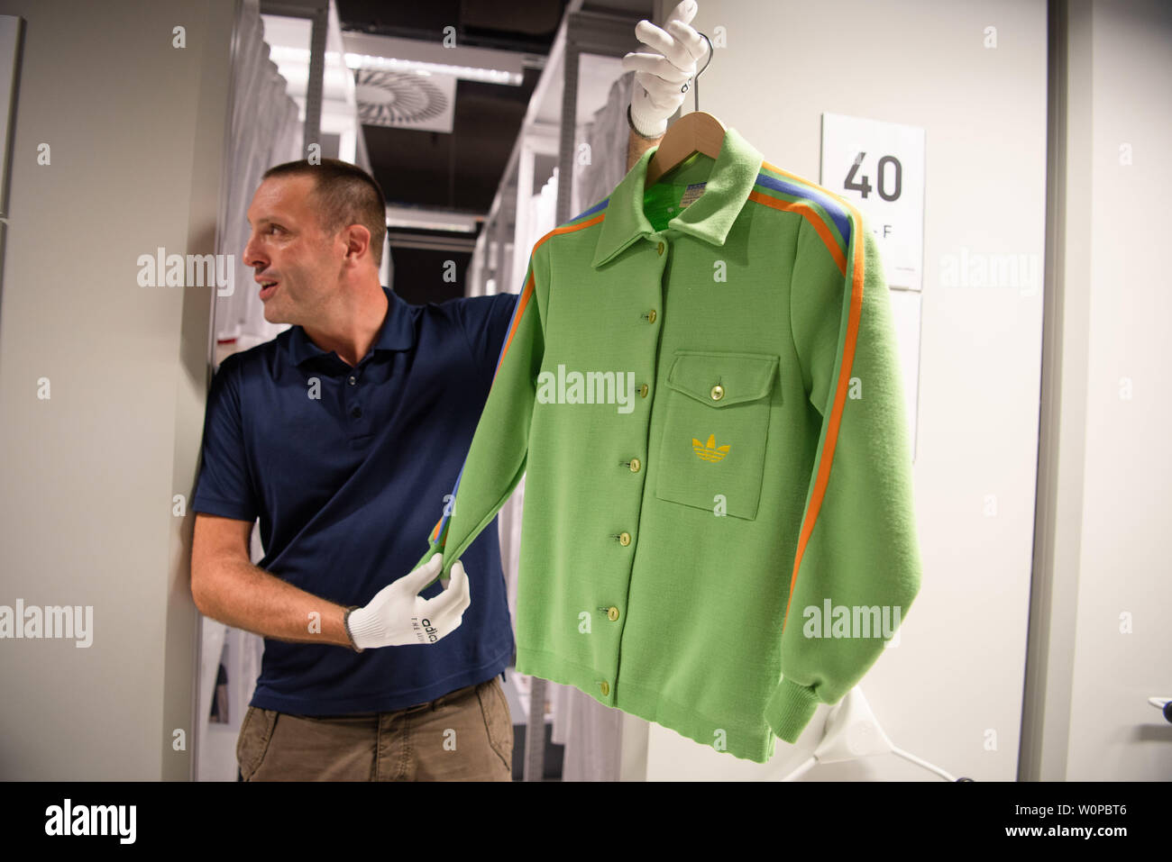 Herzogenaurach, Germany. 26th June, 2019. Martin Gebhardt, archivist of the  sporting goods manufacturer "adidas", shows the presentation suit of the  German Olympic team from 1972 in the company's archive. The ladies wear