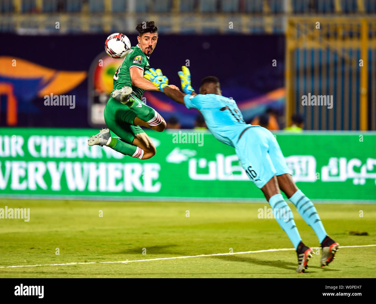 Cairo, Egypt. 27th June, 2019. Baghdad Bounedjah (L) of Algeria competes with Senegal's goalkeeper Edouard Osoque Mendy during the 2019 African Cup of Nations Group C match between Senegal and Algeria in Cairo, Egypt, on June 27, 2019. Algeria won 1-0. Credit: Li Yan/Xinhua/Alamy Live News Stock Photo