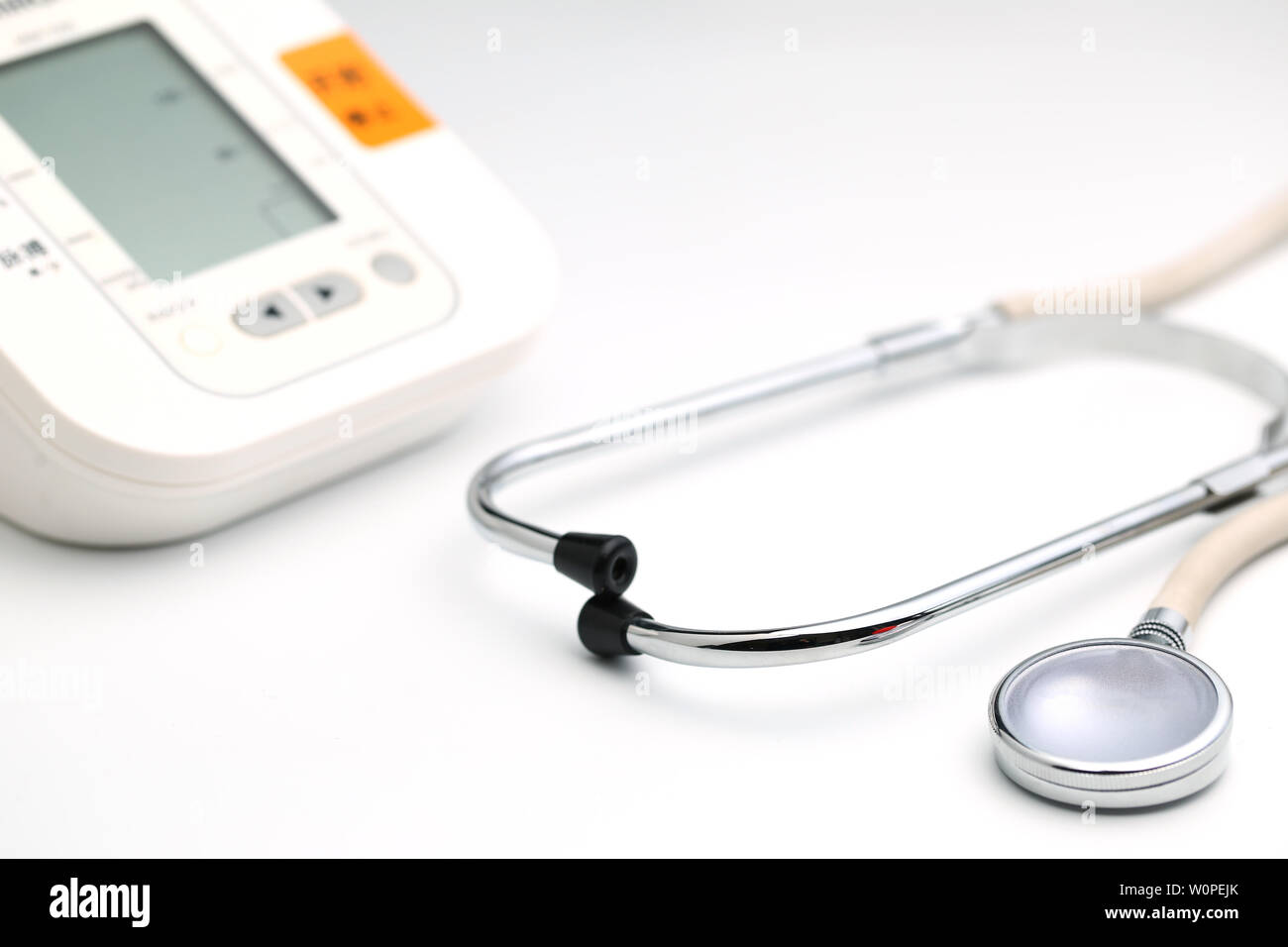 Electronic sphygmomanometer and stethoscope are placed on white