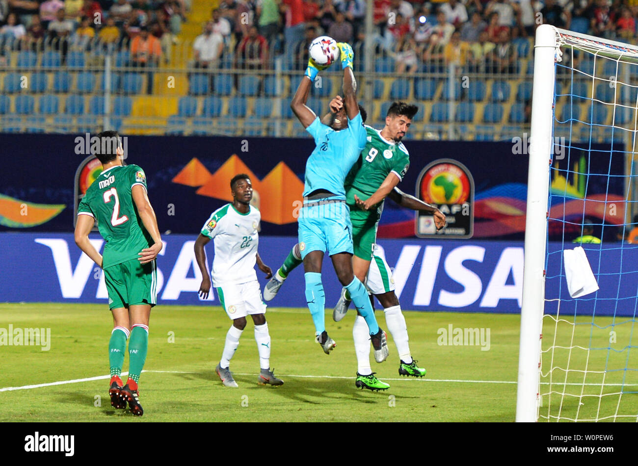 Cairo, Egypt. 27th June, 2019. Baghdad Bounedjah (1st R) of Algeria vies with Senegal's goalkeeper Edouard Osoque Mendy (2nd R) during the 2019 African Cup of Nations Group C match between Senegal and Algeria in Cairo, Egypt, on June 27, 2019. Algeria won 1-0. Credit: Li Yan/Xinhua/Alamy Live News Stock Photo