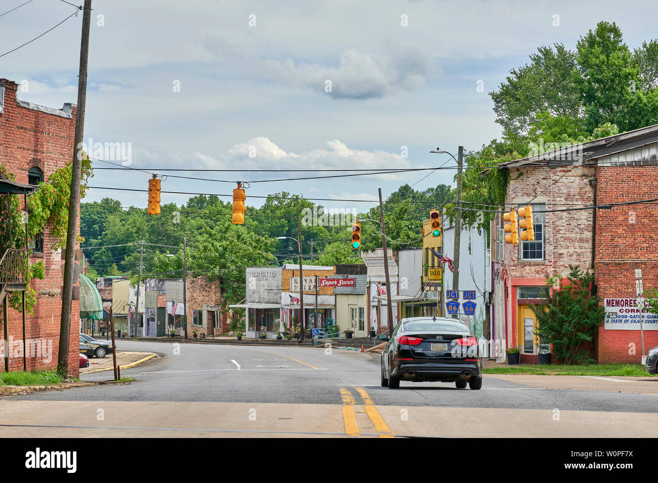 A single car driving on the main street of a small town in rural America, Goodwater Alabama, USA. Stock Photo