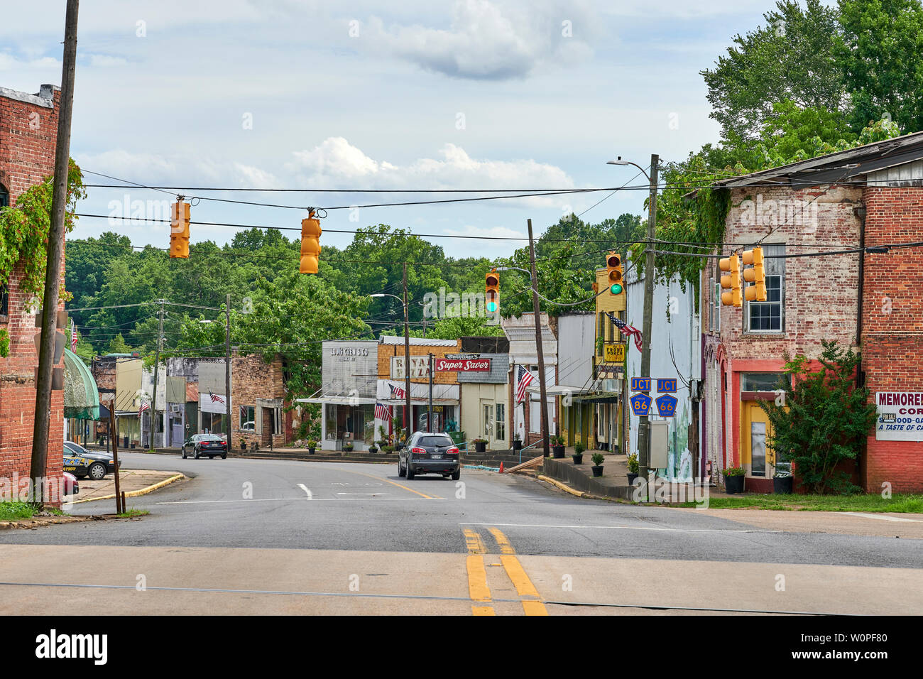 A single car driving on the main street of a small town in rural America, Goodwater Alabama, USA. Stock Photo