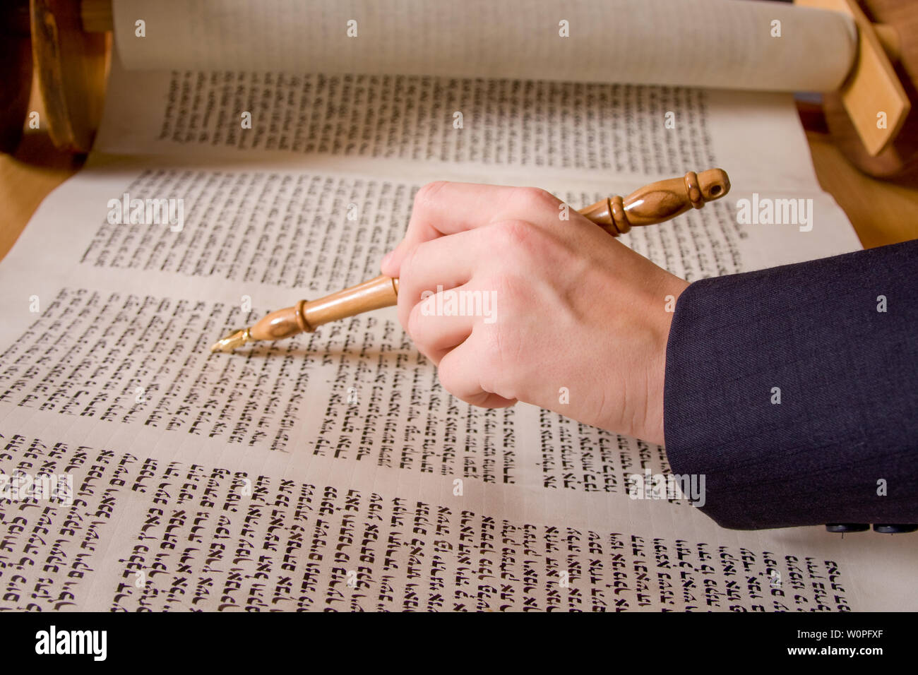 hand pointing at Hebrew writing in scripture Stock Photo
