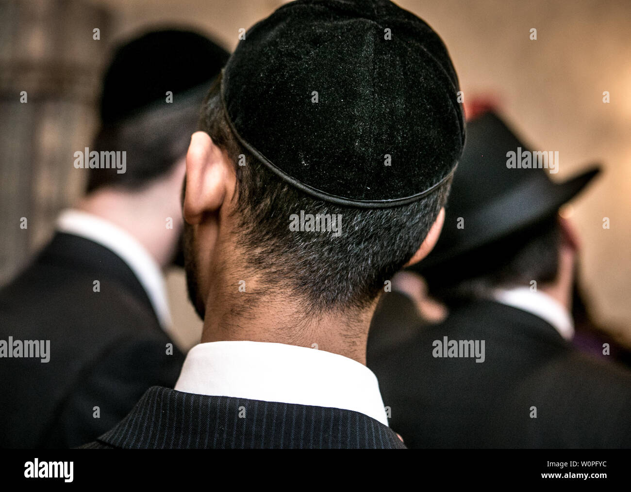 3 Jews from behind in synagogue Stock Photo