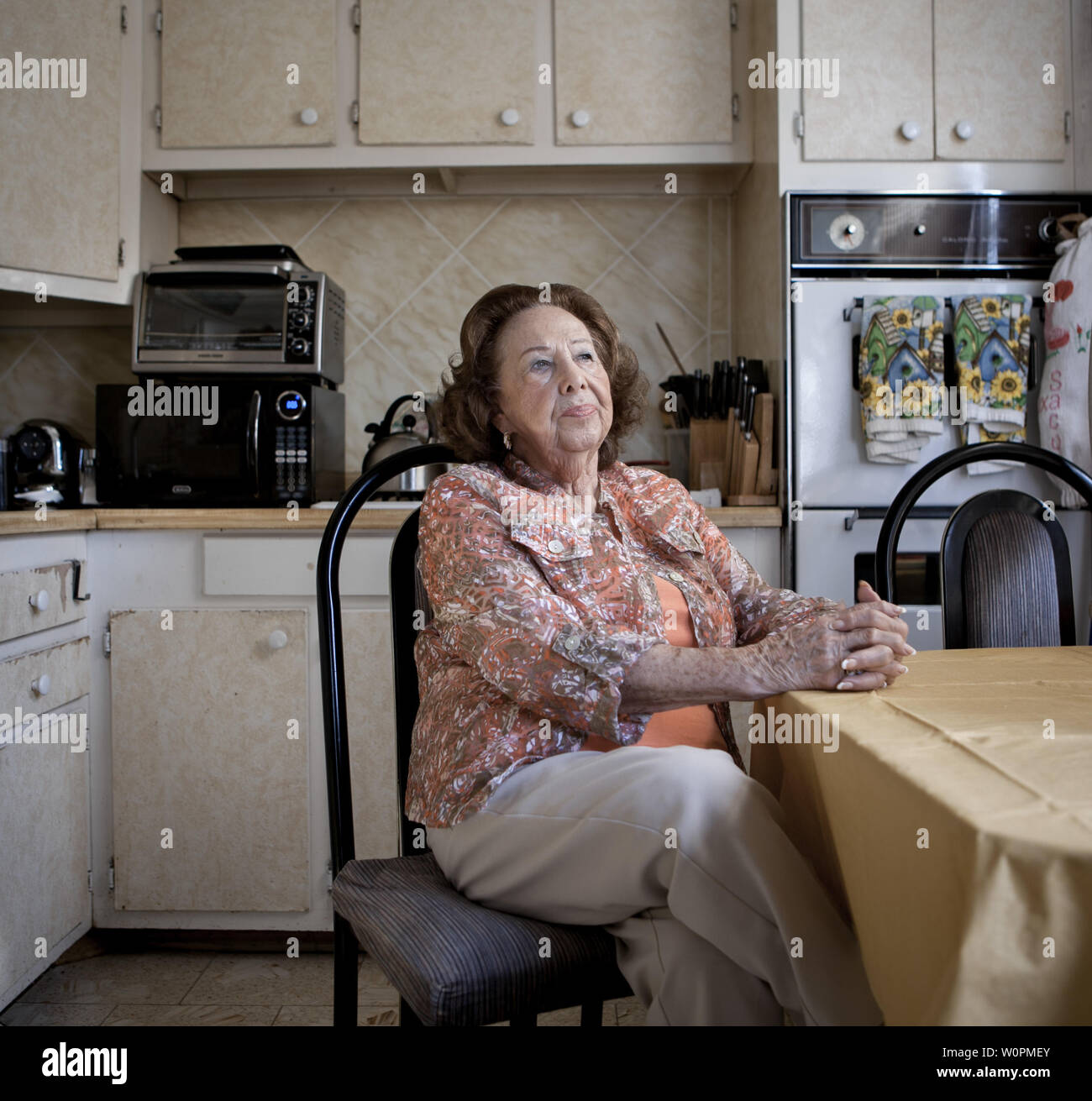 a senior woman sits in her old fashioned kitchen Stock Photo - Alamy