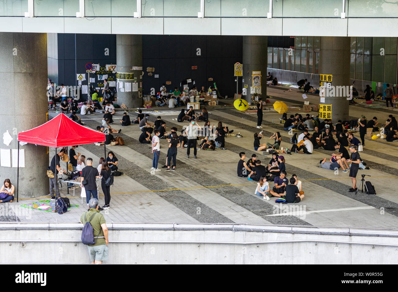 Hong Kong 2019 extradition bill protest : protesters wear black and relax with friends at base camp in front of HK government HQ Stock Photo