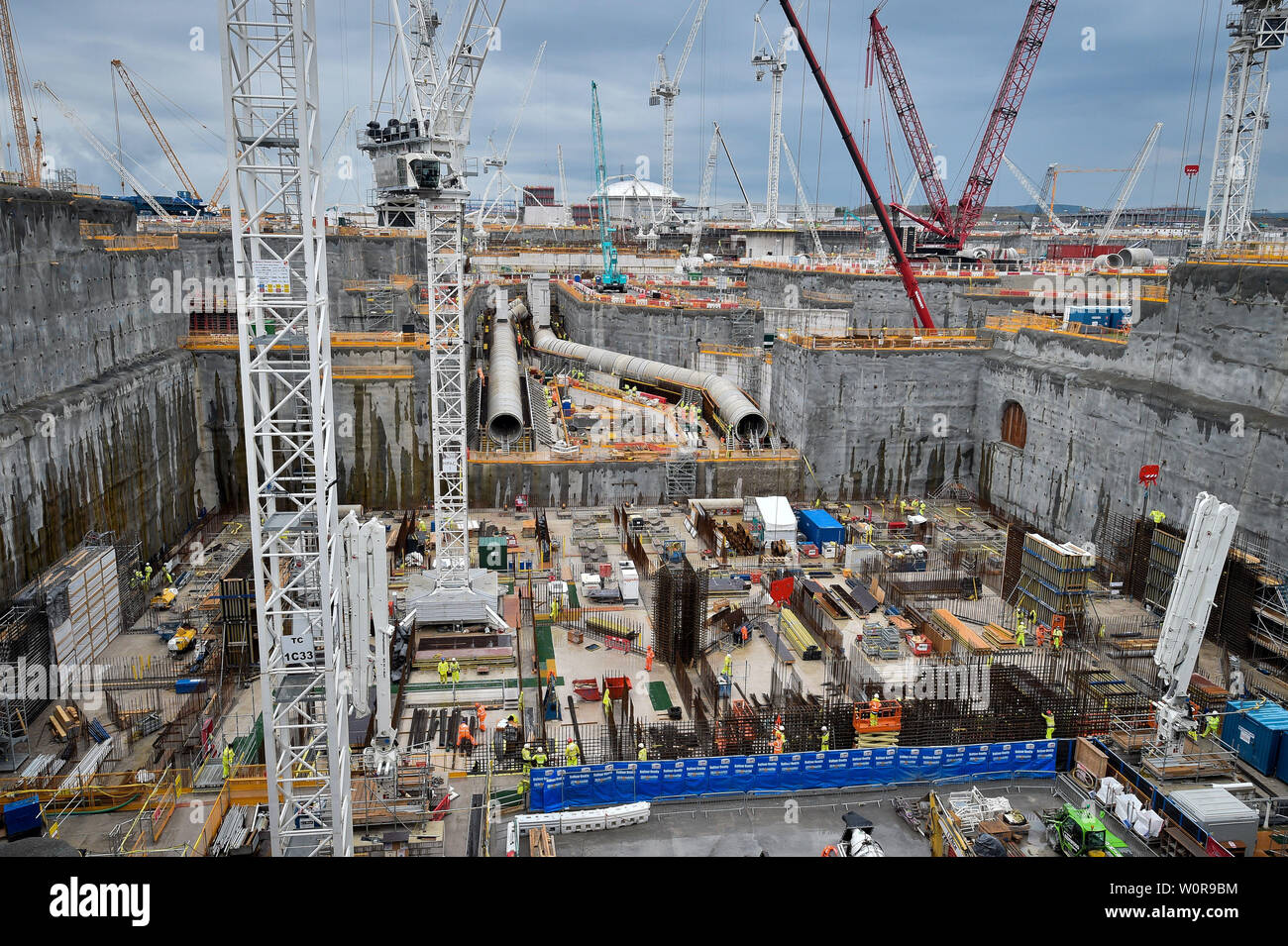 Giant water cooling pipes sit above the deep dig excavation heat-sink site during construction work at Hinkley Point C power station near Bridgwater, Somerset. Stock Photo