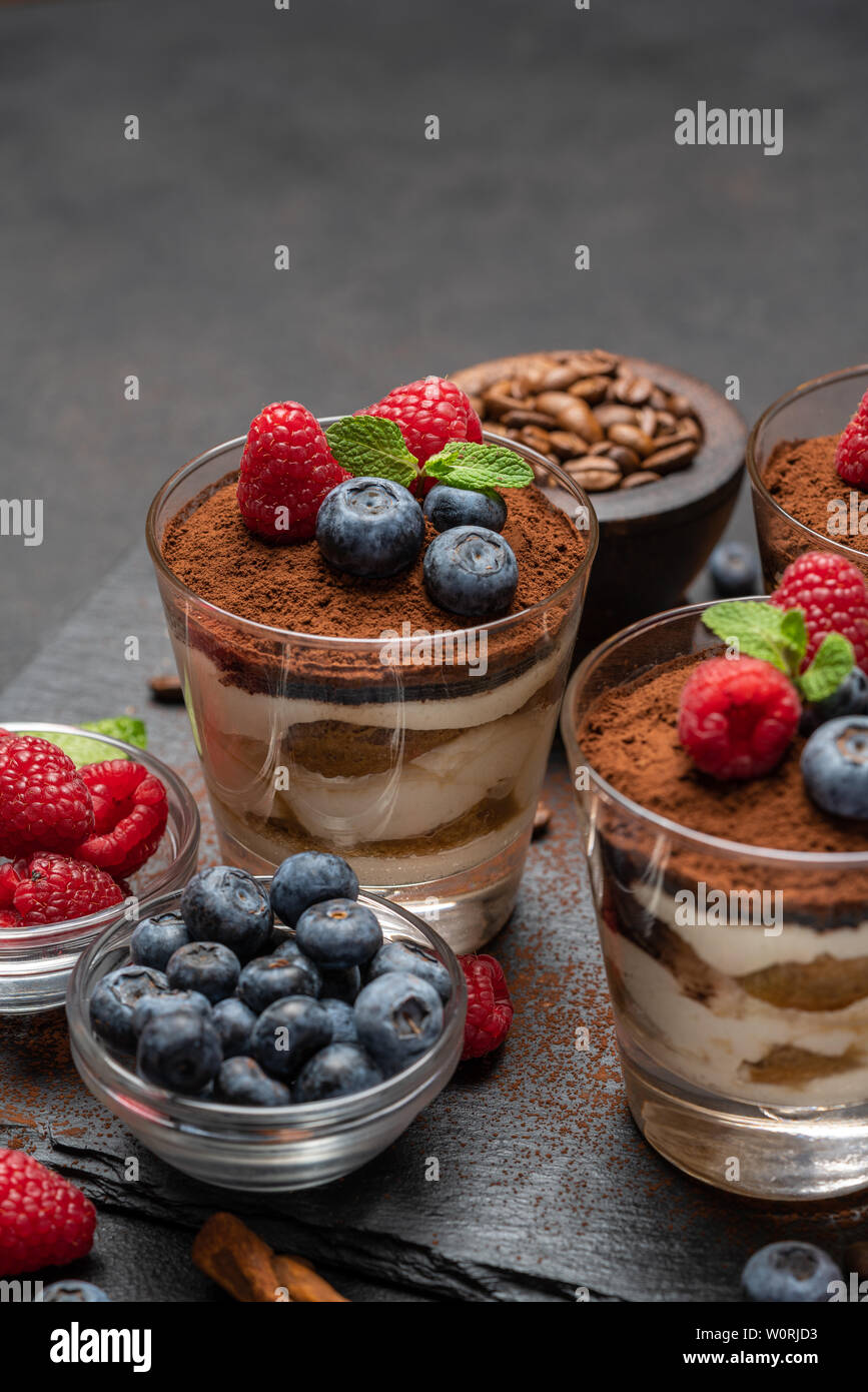 Classic tiramisu dessert with blueberries and raspberries in a glass on ...