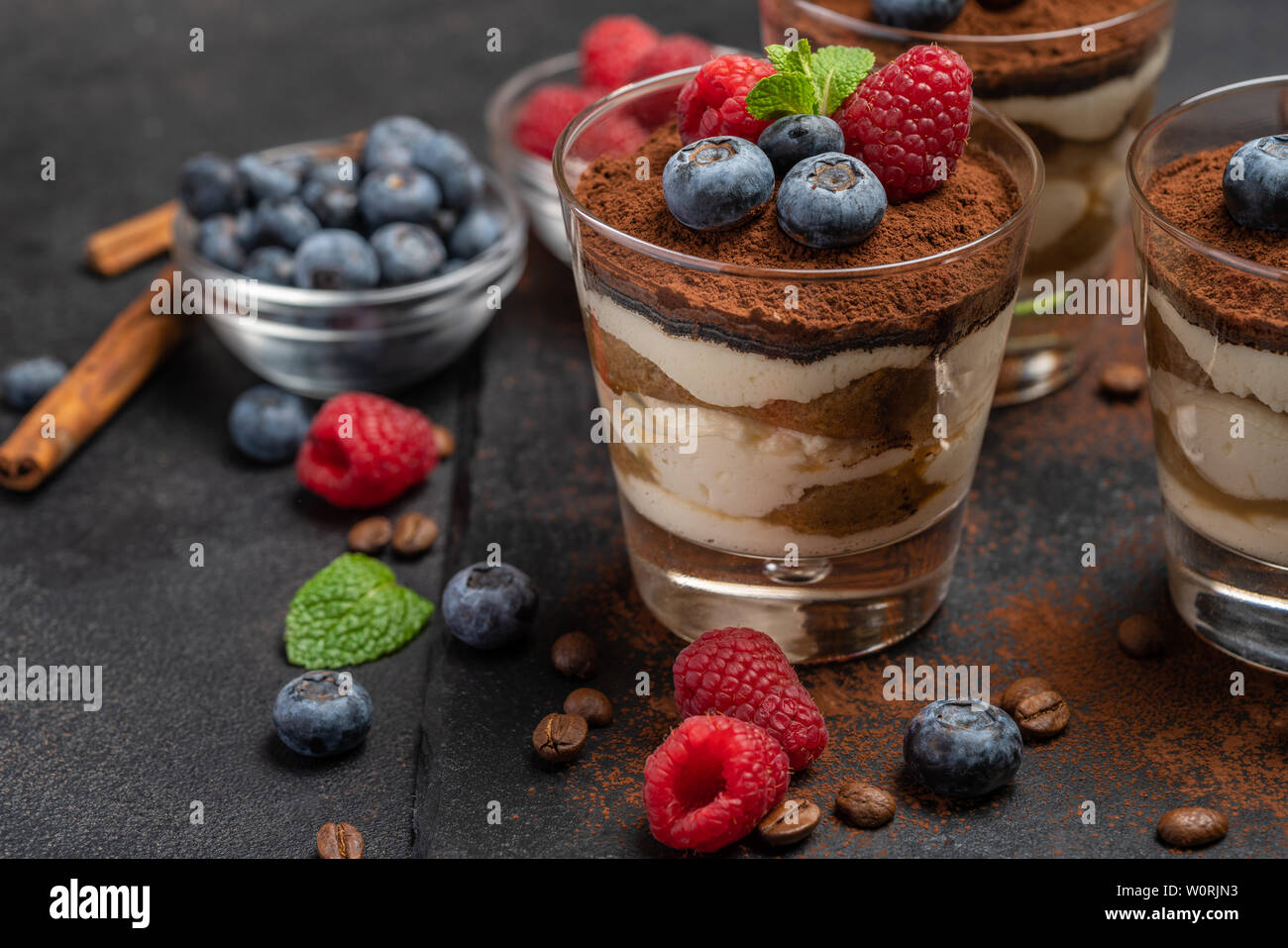 Classic tiramisu dessert with blueberries and raspberries in a glass on ...