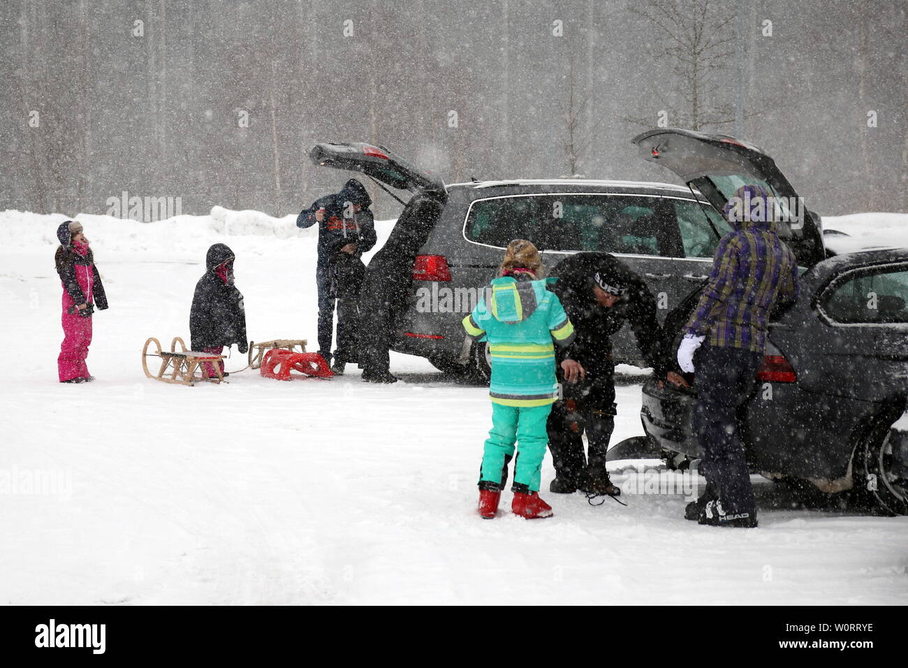 Wintersportler rüsten sich zur Freude der Kinder für einen Skitag     Wintereinbruch im Hochschwarzwald (Baden-Württemberg) - In der Feldbergregion ist der Winter mit kräftigen Schneeschauern zurückgekehrt. Wie hier in Feldberg-Bärental kommt es nach massiven Schneefällen am Samstagvormittag zu erheblichen Verkehrsproblemen. Räumfahrzeuge sind im Einsatz, doch die steckengebliebenen Autofahrer verhindern die Räumarbeiten. Busse mussten Schneeketten montieren, querstehende LKW´s mit glatten Reifen taten ihr übriges. Stock Photo
