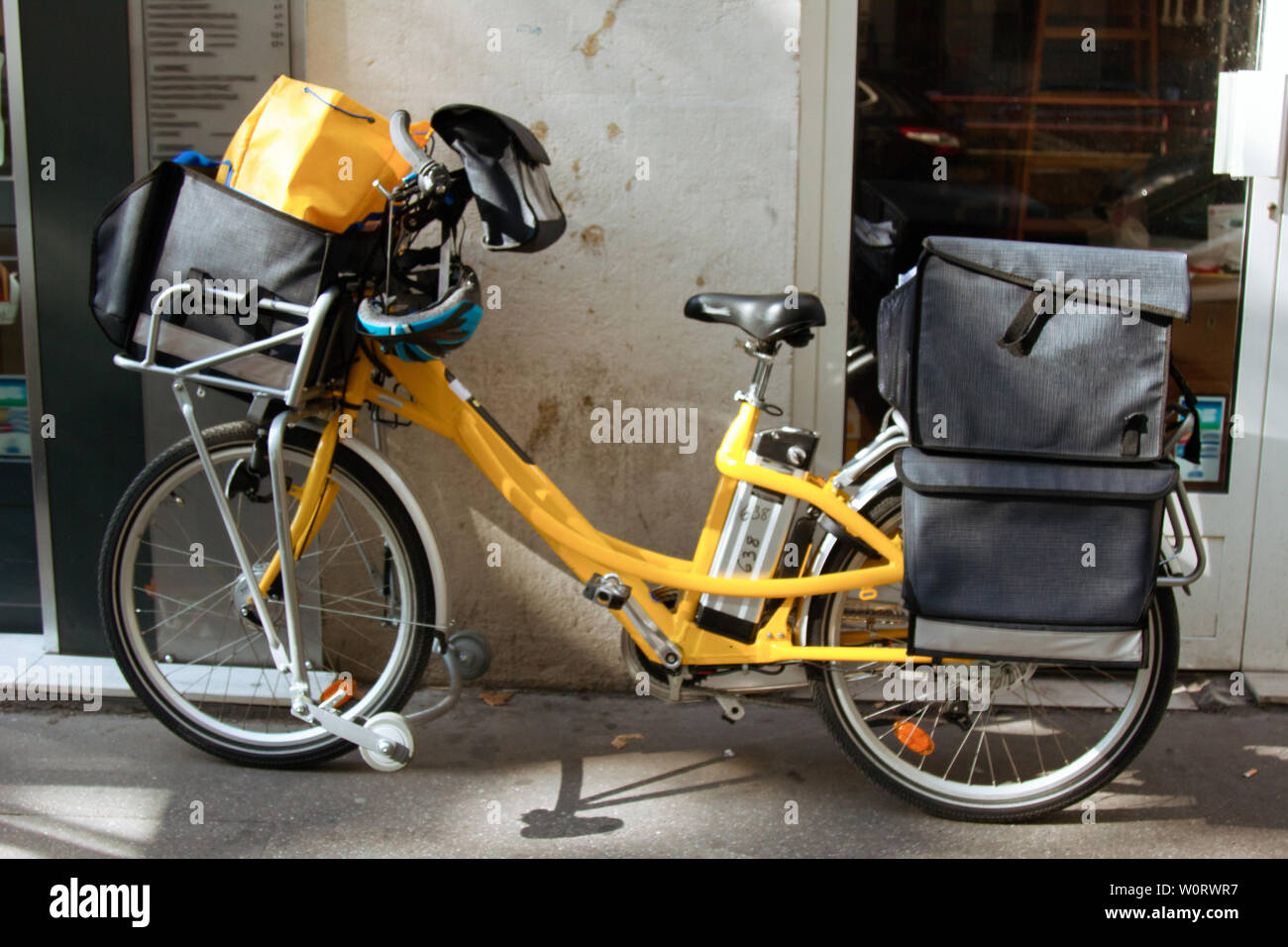 Special yellow courier bike with Bicycle bags at the door of the institution Stock Photo