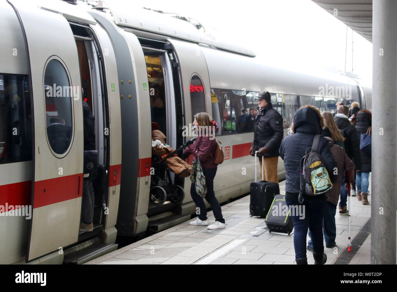 Reisende am Hauptbahnhof in Freiburg im Breisgau, eine Frau schiebt einen Kinderwagen vom Bahnsteig in den ICE-Zug Stock Photo