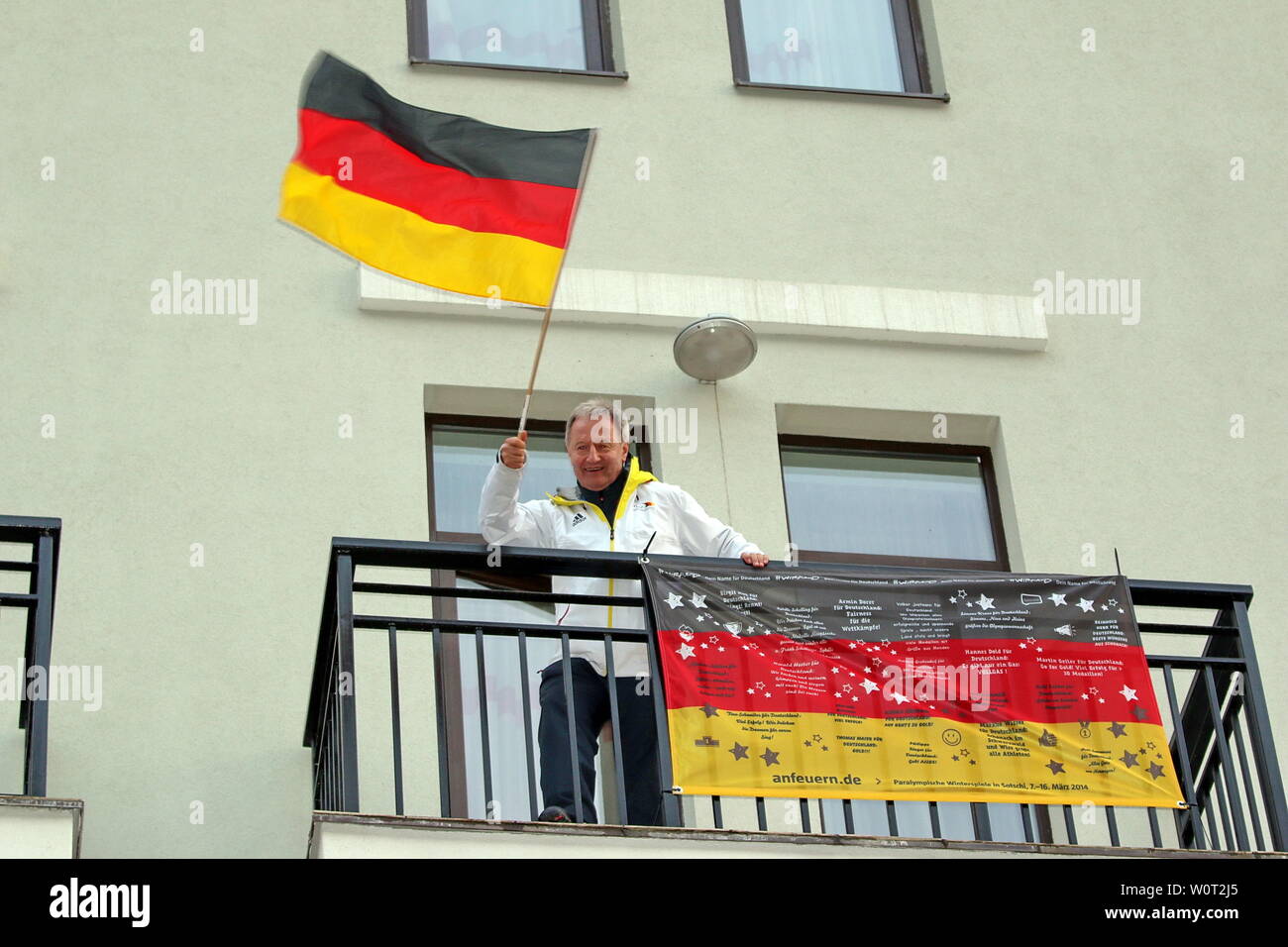 DBS-Präsident Friedhelm Julius BEUCHER hat gut jubeln in diesen Tagen und grüßt mit der deutschen Flagge vom Balkon seines Hotelzimmers in Rosa Khutor - Siegerehrung Rosa Khutor Ski Alpin 6. Tag Paralympics Sotschi  Paralympics Sotschi 2014 / Paralympic Winter Games Sochi 2014 Stock Photo