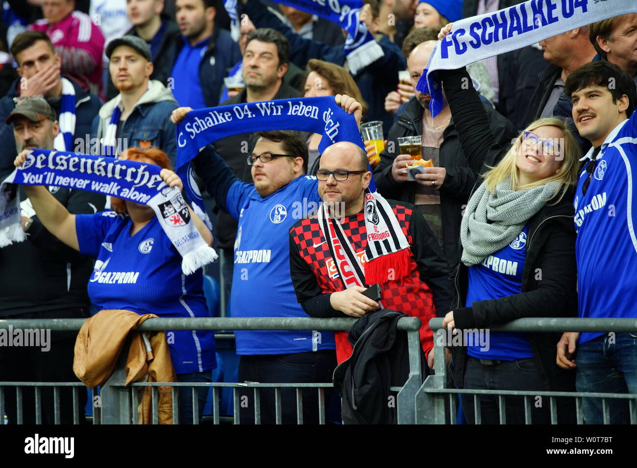 Schalke-Fans jubeln - SC Fan nachdenklich beim Spiel der  1. BL: 17-18 -28. Spieltag - Schalke 04 vs SC Freiburg Stock Photo