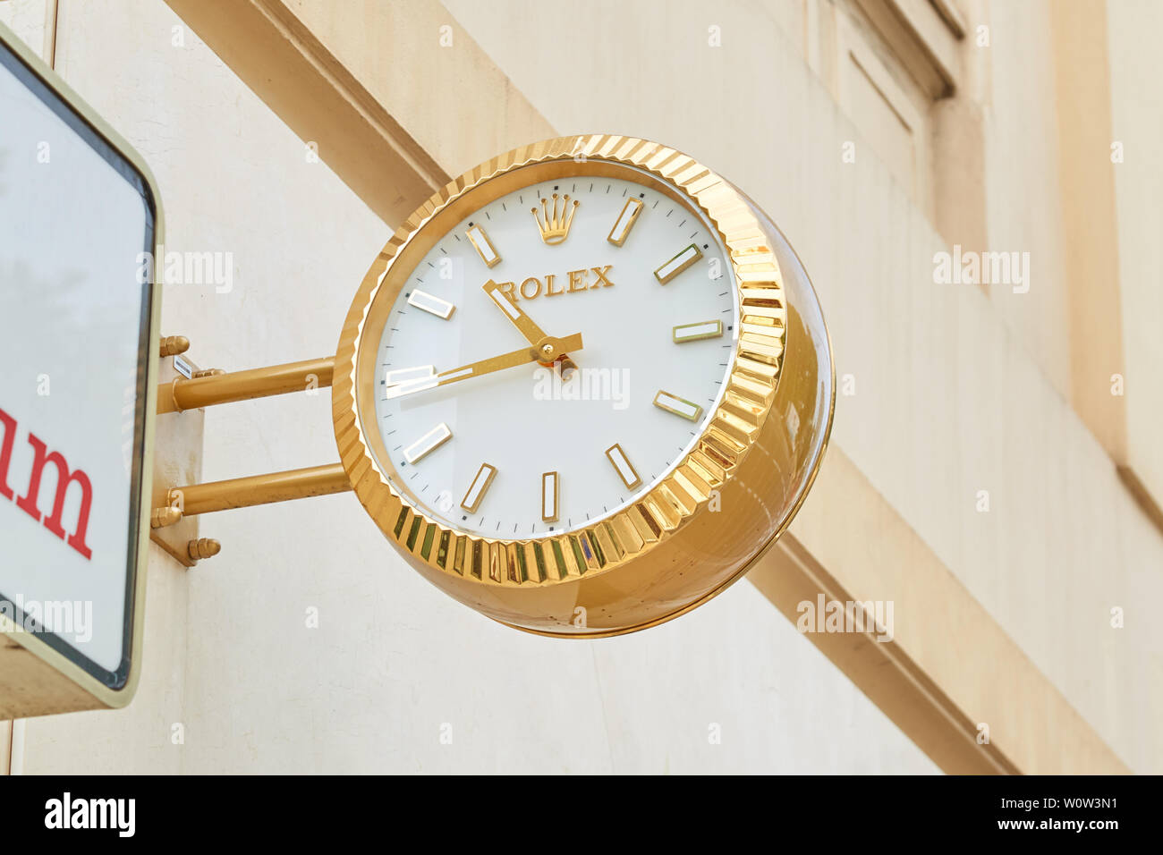 MONTE CARLO, MONACO - AUGUST 20, 2016: Rolex golden clock close to jewelry sign, luxury store in Monte Carlo, Monaco. Stock Photo