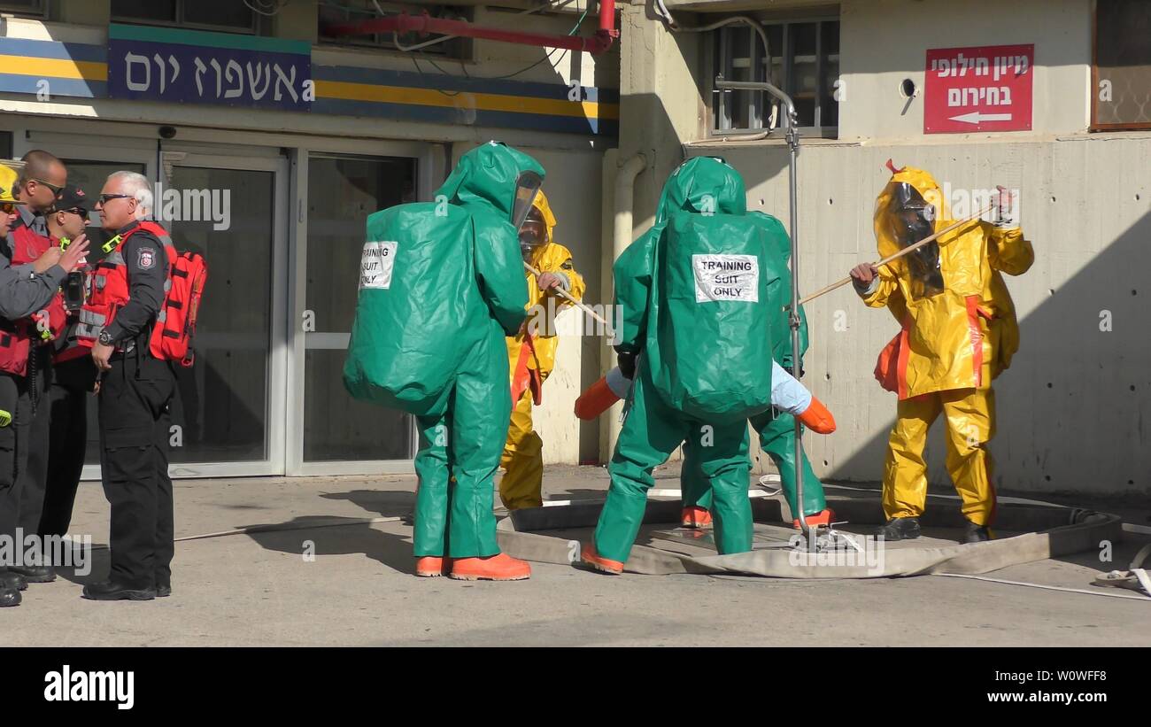 Firefighters dressing protective suites cleaning victims from leaking toxic medical gases in Haemek Hospital during drill. Afula, Israel, January 30, 2017 Stock Photo