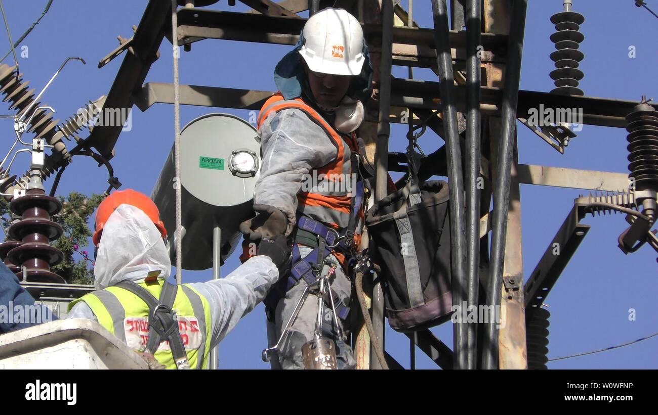 Electricians of the Israeli Electric Co fixing high voltage electrical lines, replacing a