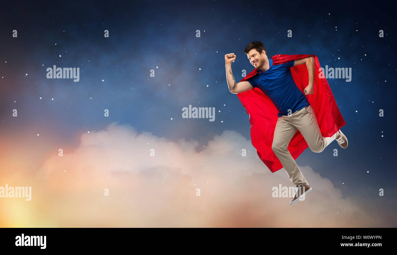man in red superhero cape flying over night sky Stock Photo - Alamy