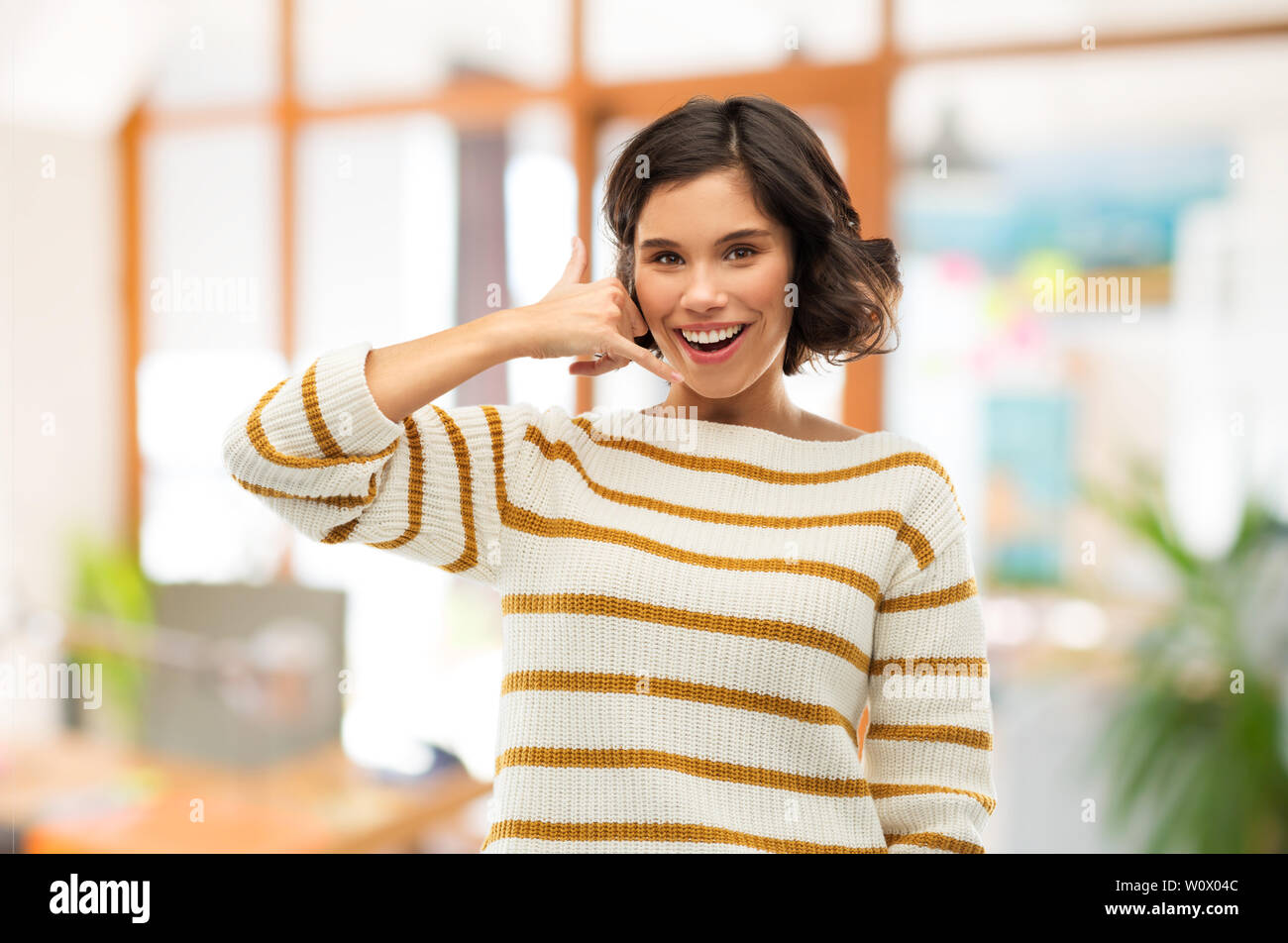 happy smiling woman showing phone call gesture Stock Photo