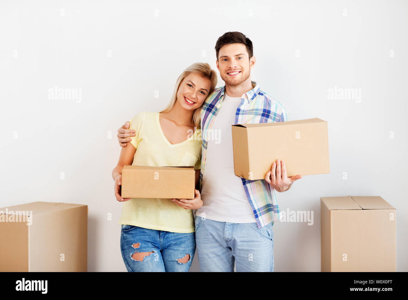happy couple with boxes moving to new home Stock Photo - Alamy