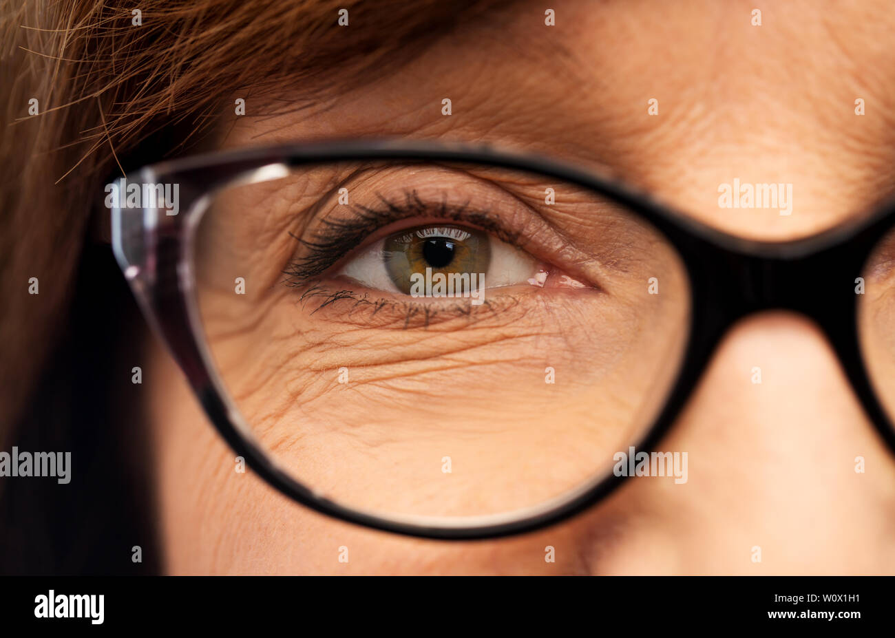 close up of face of senior woman in glasses Stock Photo