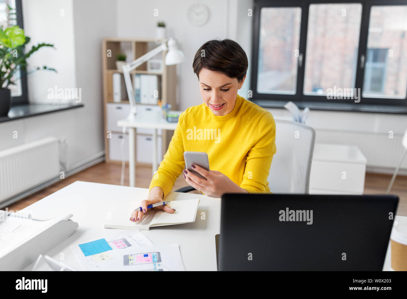 smiling ui designer using smartphone at office Stock Photo