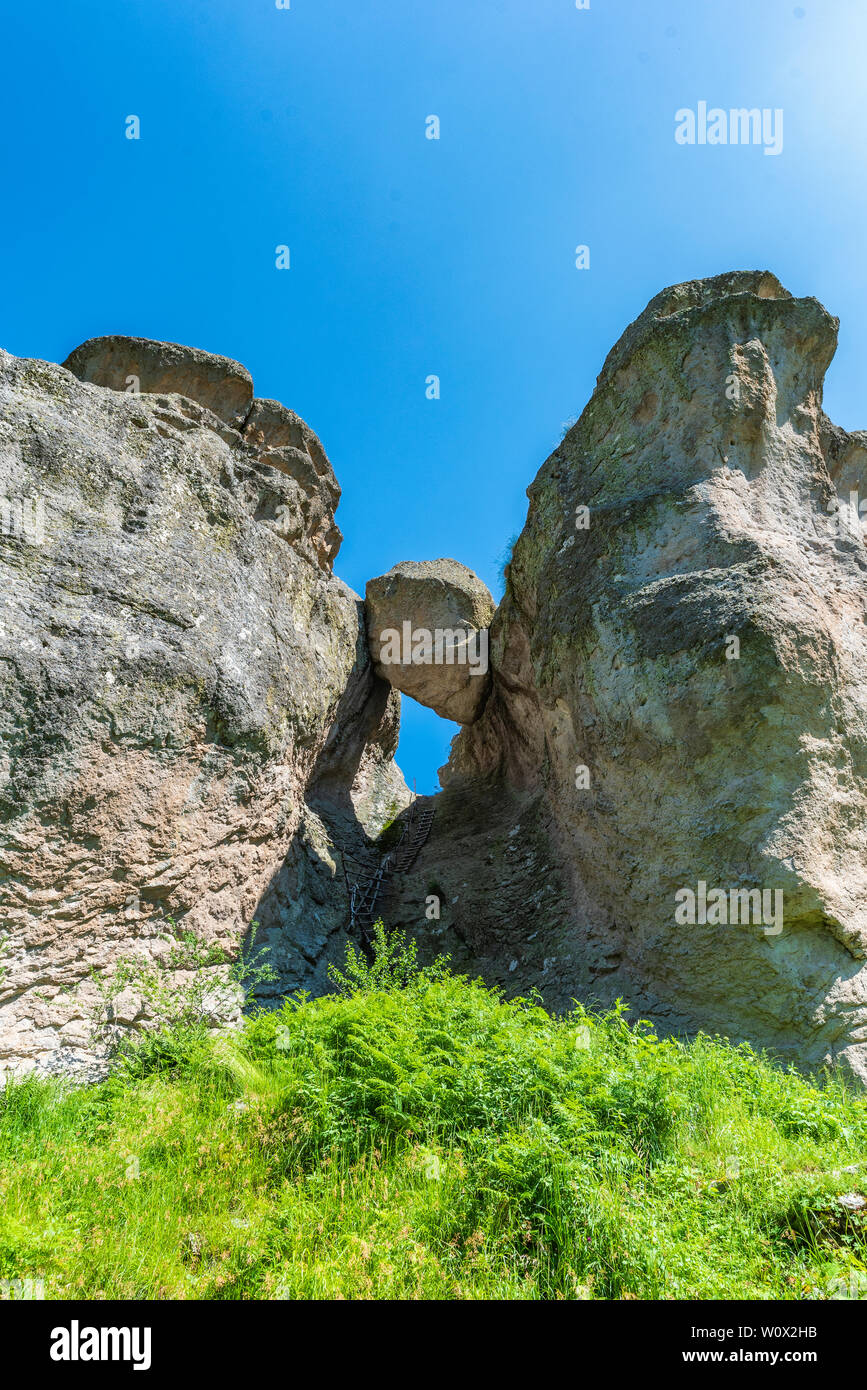 Natural rock formation consisting of big stone stuck between two rocks in the Rhodope mountain in Bulgaria (called in Bulgarian Karadzhov Kamak) Stock Photo