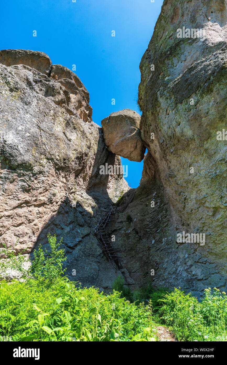 Natural rock formation consisting of big stone stuck between two rocks in the Rhodope mountain in Bulgaria (called in Bulgarian Karadzhov Kamak) Stock Photo