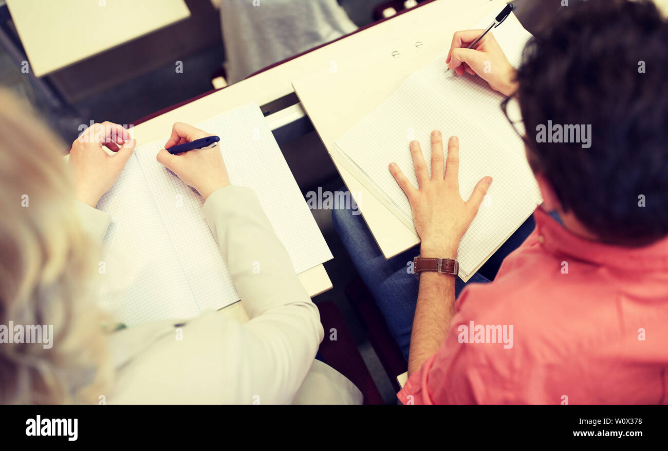 students writing to notebooks at exam or lecture Stock Photo