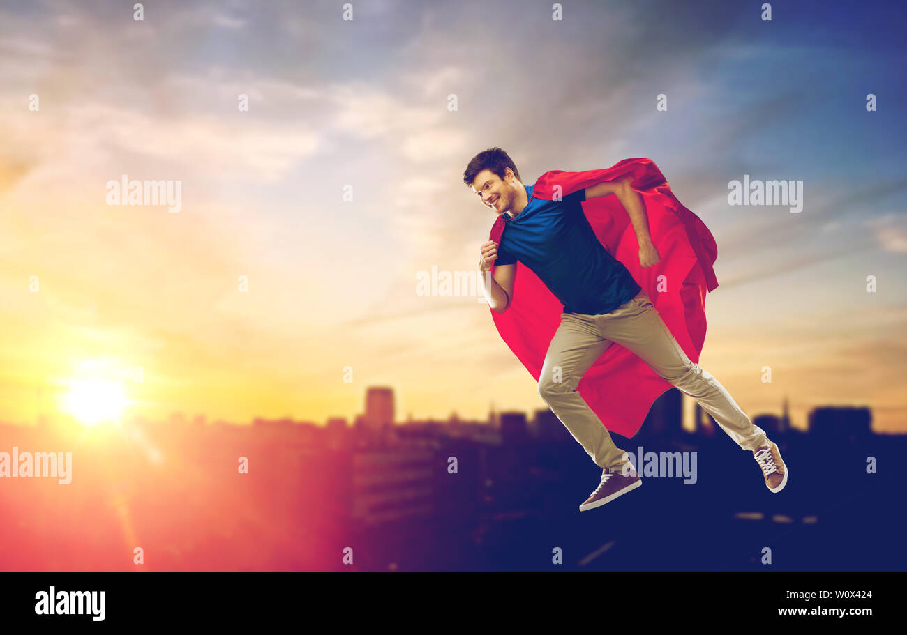 man in superhero cape flying over sunset in city Stock Photo - Alamy
