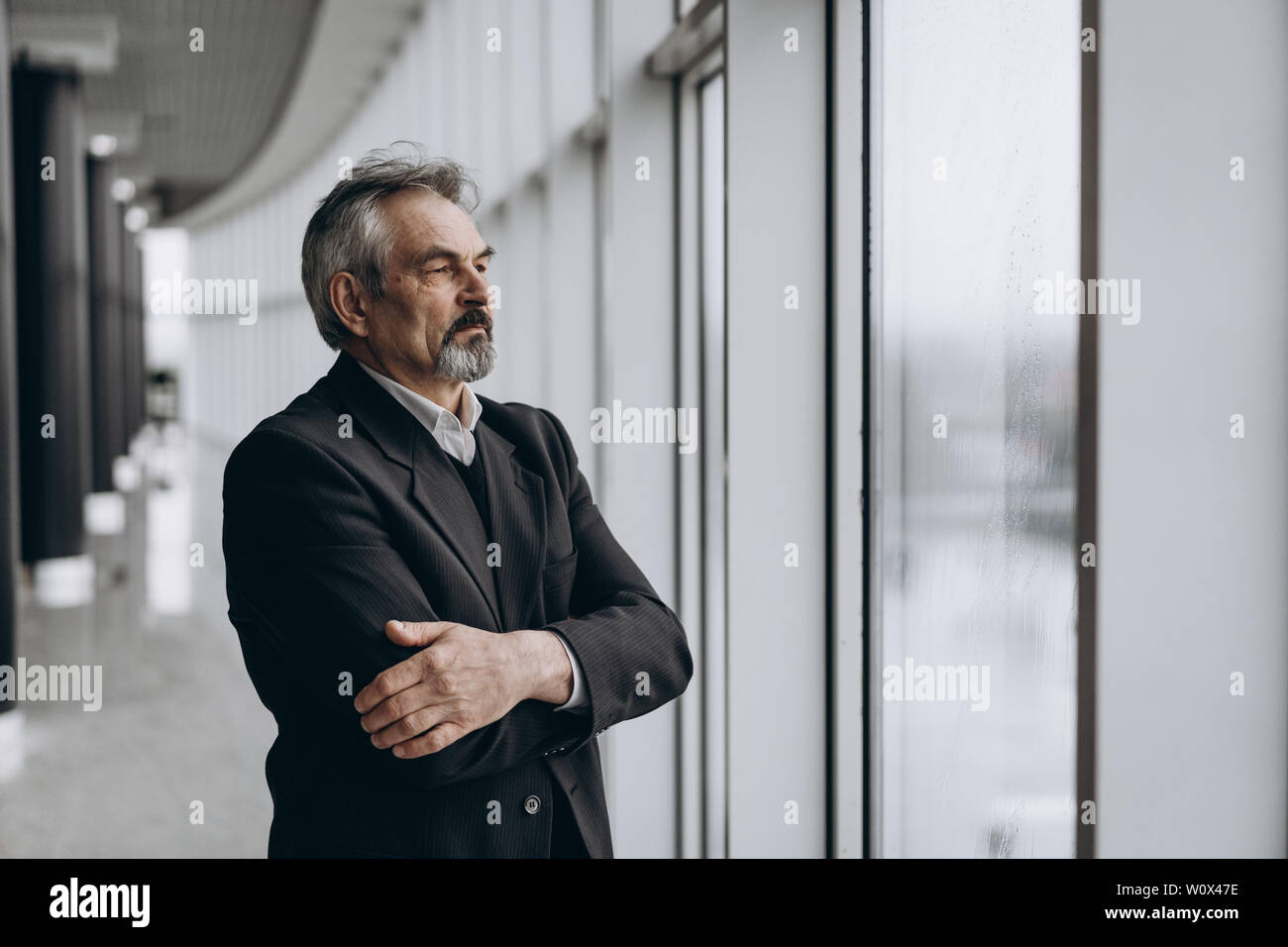 Serious elder man in big office centre Stock Photo