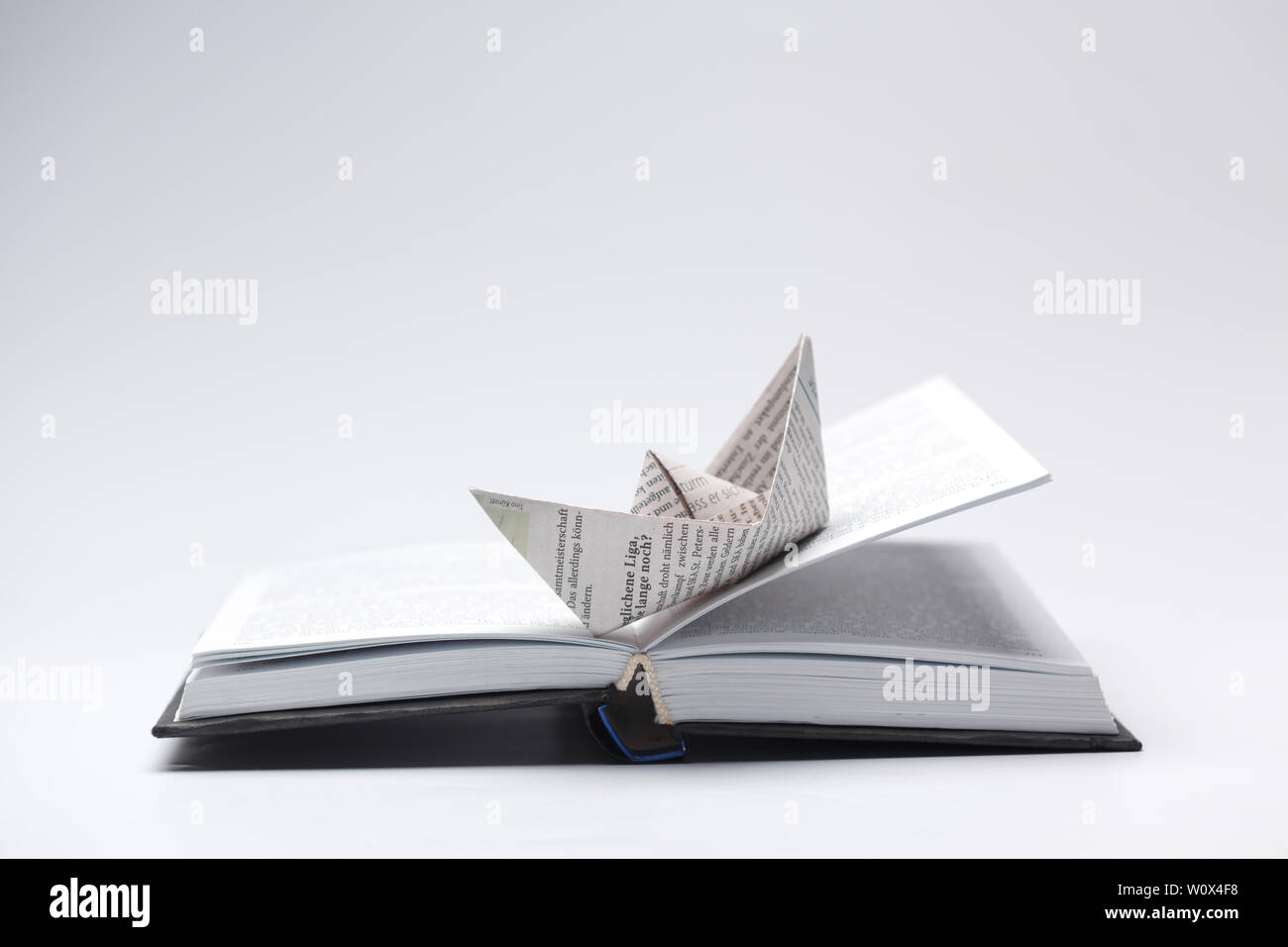 Origami paper boat on a book Stock Photo Alamy