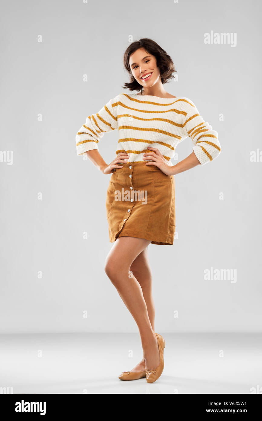young woman in striped pullover, skirt and shoes Stock Photo