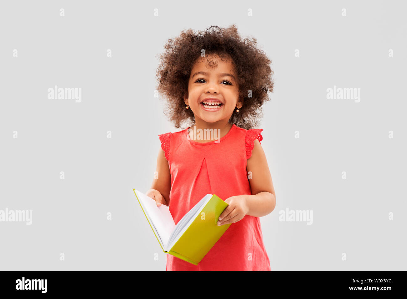 happy little african american girl with book Stock Photo - Alamy