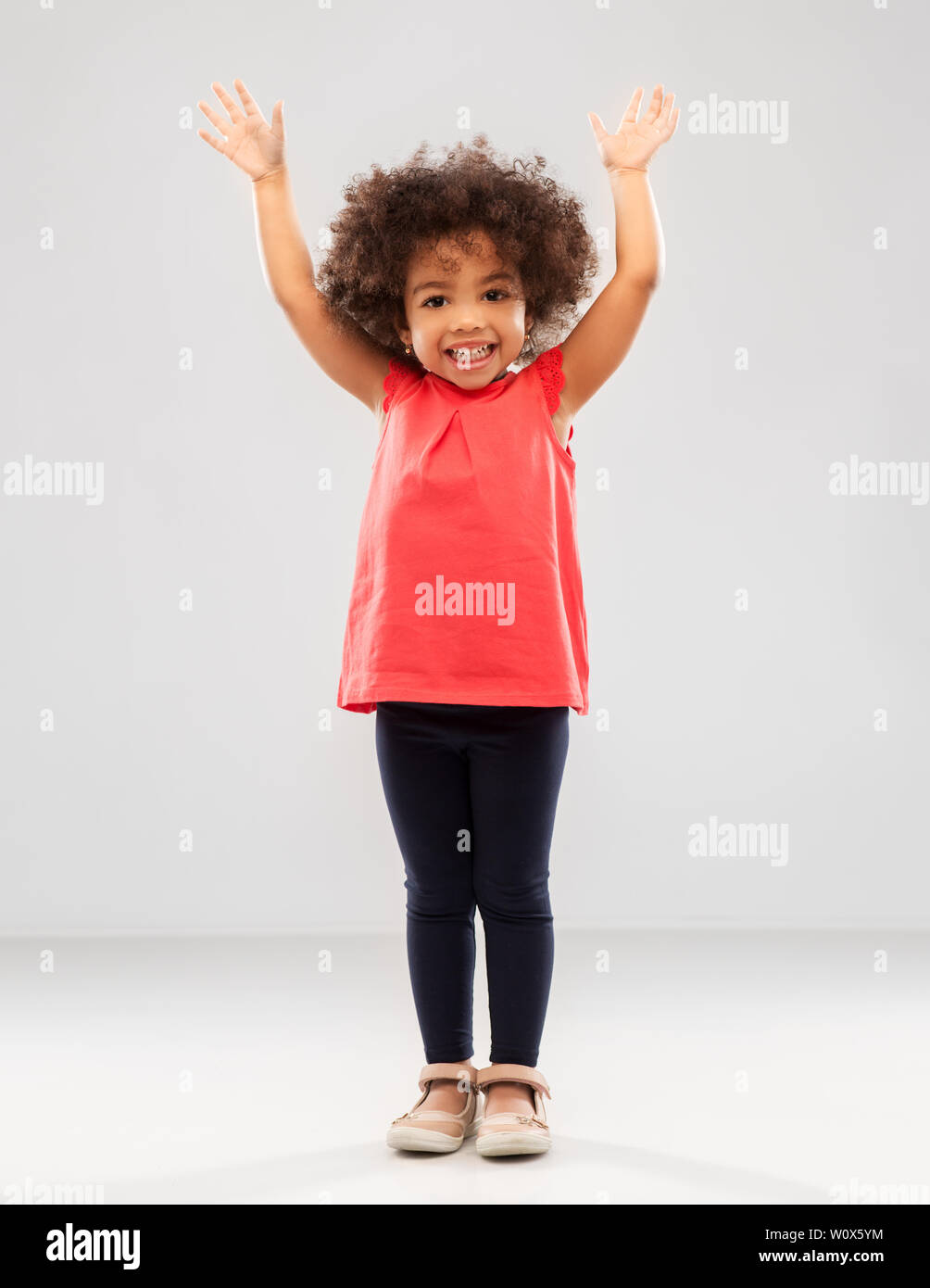 happy little african american girl with hands up Stock Photo - Alamy