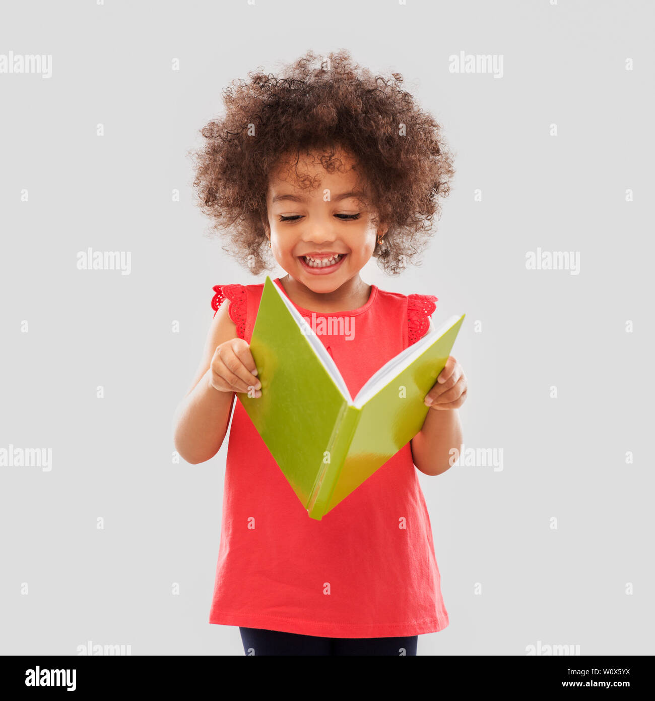 happy little african american girl reading book Stock Photo - Alamy